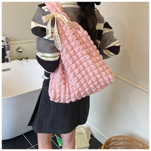 Detail of pink bubble texture tote bag featuring a white lace bow and spacious interior