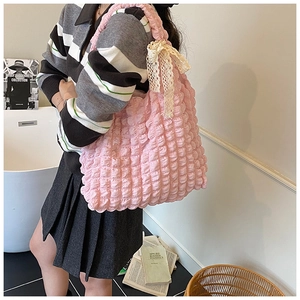 Detail of pink bubble texture shoulder bag with decorative cream lace bow detail