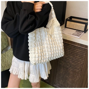 Close-up of white popcorn textured tote bag with delicate lace bow detail