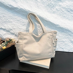 Minimalist beige corduroy tote bag with side pockets and a stylish vertical texture