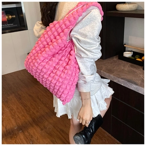 Detail of a large pink shoulder bag with unique bubble texture and pleated design