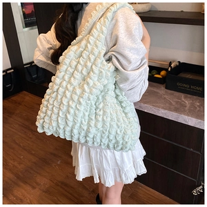 Detailed close-up of light green cloud-textured pleated tote bag with popcorn fabric