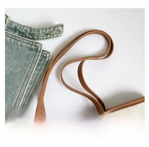 Close-up of the brown faux leather handle and textured floral print on the tote bag