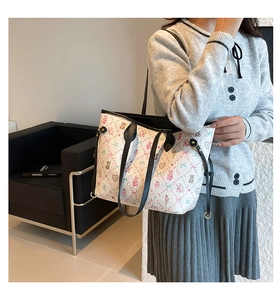 Detail of white tote bag with cute cartoon bear print and black contrasting handles