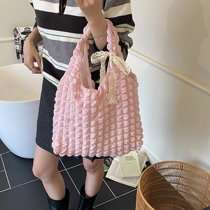 Pink popcorn texture tote bag with cream lace bow shown by a model in a lifestyle setting