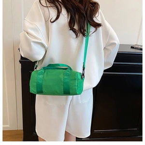 Dettaglio della borsa sportiva cilindrica verde con tracolla e trama in nylon