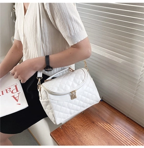 Detailed close-up of white quilted PU leather crossbody bag with gold metal zippers and hooks