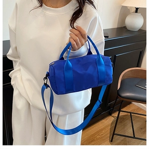 Dettaglio borsa a bauletto in nylon blu con tracolla rimovibile e manici robusti