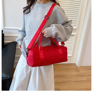 Borsa sportiva cilindrica rossa con tracolla regolabile e manici superiori resistenti