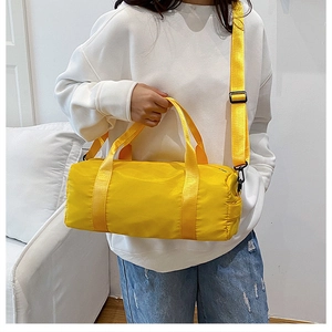 Dettaglio borsa fitness cilindrica giallo con tracolla nera regolabile per sport