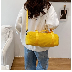 Vista posteriore di una borsa a cilindro in nylon giallo portata da una modella