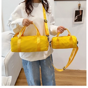 Detail of bright yellow cylinder gym bags in two sizes featuring black zippers and straps