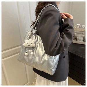 Detail of silver metallic tote bag with quilted texture and cute cloud plush charm