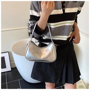 Silver metallic hobo shoulder bag with wrinkled texture shown on model in a modern room