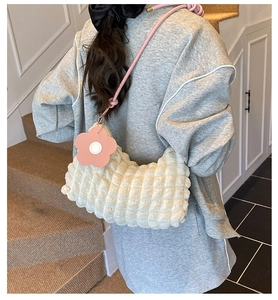 Détail du sac à texture bulles blanche avec bandoulière rose et pendentif fleur de soleil