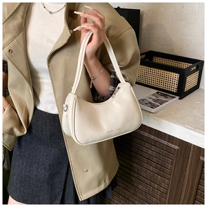 Detail of minimalist cream faux leather underarm bag with Fashion & Bags text
