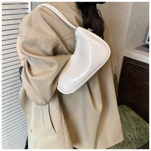 Detailed close-up of ivory minimalist underarm bag featuring sleek fashion lettering