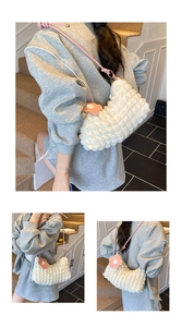 Détail du sac à main plissé avec breloque fleur rose et bandoulière à nœud élégant
