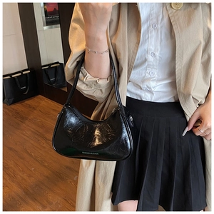 Detail view of black glossy underarm bag with white FASHION & BAGS logo print