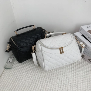 Chic quilted leather makeup bag with handle and gold zipper shown in black and white