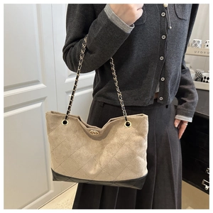 Détail du sac à bandoulière beige matelassé avec bandoulière chaîne et fermoir doré