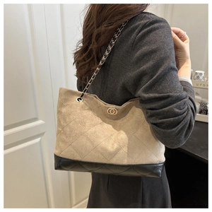 Détail du sac cabas à carreaux avec bandoulière chaîne et empiècement en cuir