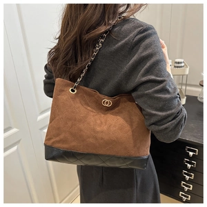 Détail du sac cabas en daim marron avec matelassage et chaîne dorée
