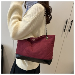 Détail du sac cabas matelassé bordeaux avec bandoulière chaîne présenté sur un mannequin