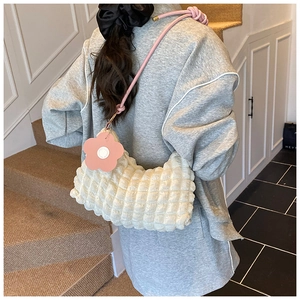 Détail du sac à bandoulière blanc à texture bulles avec breloque fleur rose