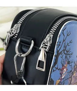 Détail de la double fermeture éclair argentée et motif sorcière sur le sac noir
