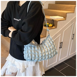 Détail du sac à bandoulière bleu clair plissé avec pendentif en forme de fleur