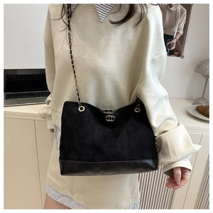 Detail of vintage quilted leather stitching and metal chain strap on black tote bag