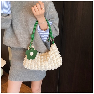 Détail du sac blanc à texture bulle avec poignée en corde verte et breloque fleur