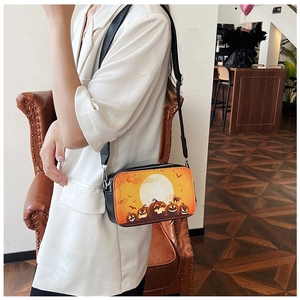 Modèle portant un petit sac carré Halloween avec motifs citrouilles et détails argentés