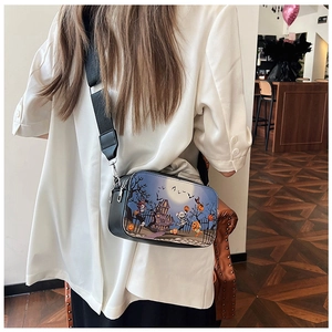 Détail d'un petit sac carré Halloween avec imprimé citrouille porté en bandoulière
