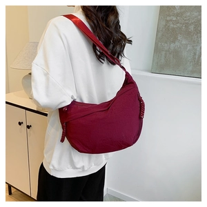 Detail of burgundy nylon hobo bag showing the woven knot zipper and soft texture