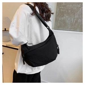 Detail of adjustable strap and minimalist black nylon crescent bag on model