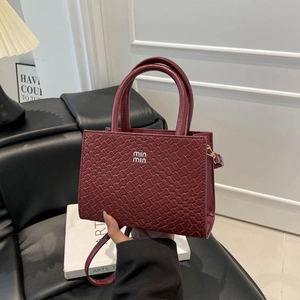 Sophisticated burgundy woven tote bag with silver logo and dual handles for women