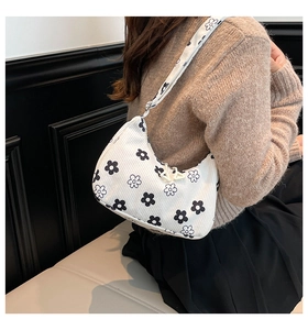 Florale Cord-Hobo-Tasche an der Schulter, die Größe und Gänseblümchenmuster zeigt