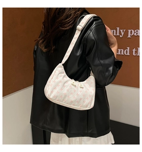 Close-up of pink floral corduroy shoulder bag with adjustable strap and metal hardware