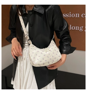 Detail of white corduroy crescent bag with lavender floral print and adjustable strap