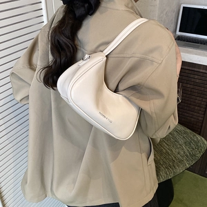 Minimalist cream white shoulder bag for women with smooth leather texture and curved shape
