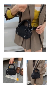 Detail of black suede Boston bag showing silver rivets and detachable leather strap