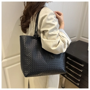 Detail of hand-woven black leather tote bag showing large capacity and minimalist design