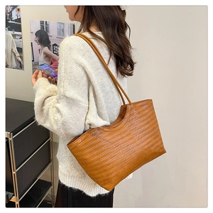 Detailed view of brown woven texture on a minimalist vintage tote bag with thin straps