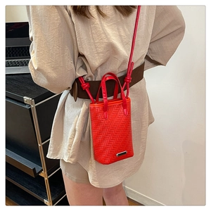 Close-up of red woven mini tote bag showing detailed V-shaped texture and metal base