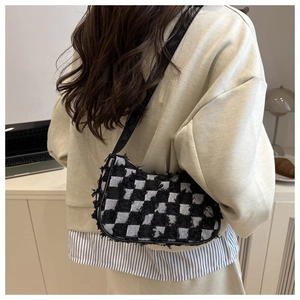 Chic black and white checkered tweed shoulder bag with fringe detail shown on a model