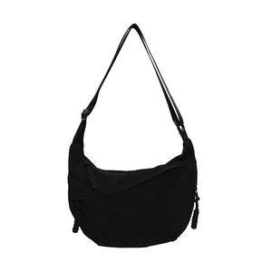 Minimalist black nylon crescent shoulder bag with adjustable strap and braided zipper detail