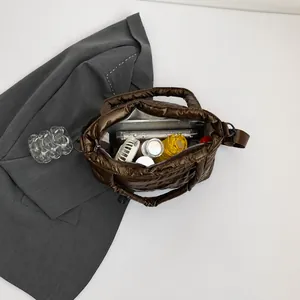Top view showing large interior capacity of brown quilted puffer tote bag with daily items