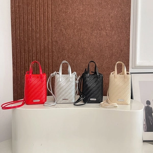 Mini woven tote bags in four colors with shoulder straps and metal logo details